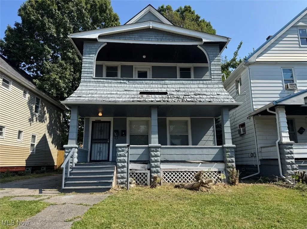 View of front facade featuring a porch, a front lawn, and a balcony