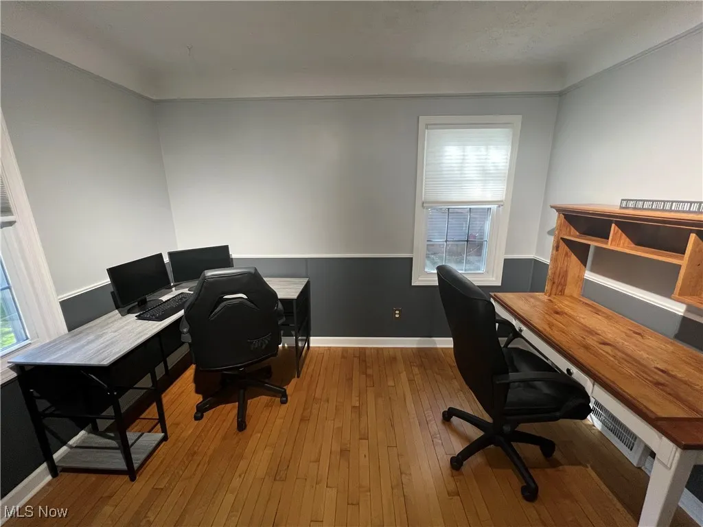 Office area with plenty of natural light, hardwood / wood-style floors, and ornamental molding