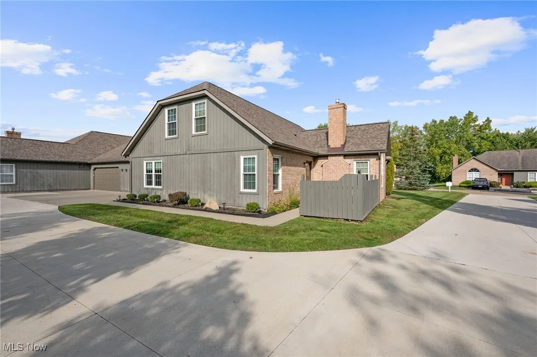 View of front of home featuring concrete driveway, a chimney, and a front lawn