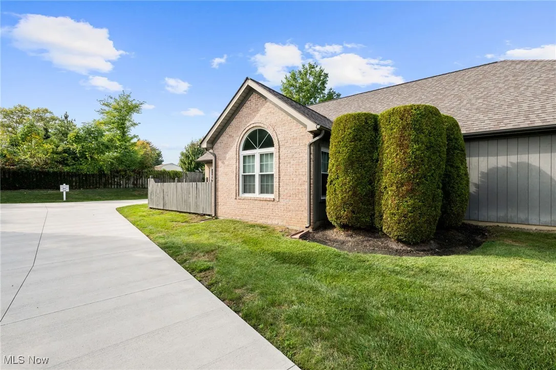View of property exterior featuring brick siding and roof with shingles