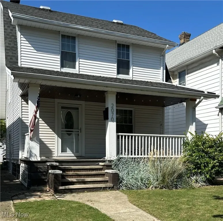 View of front facade featuring a porch and roof with shingles