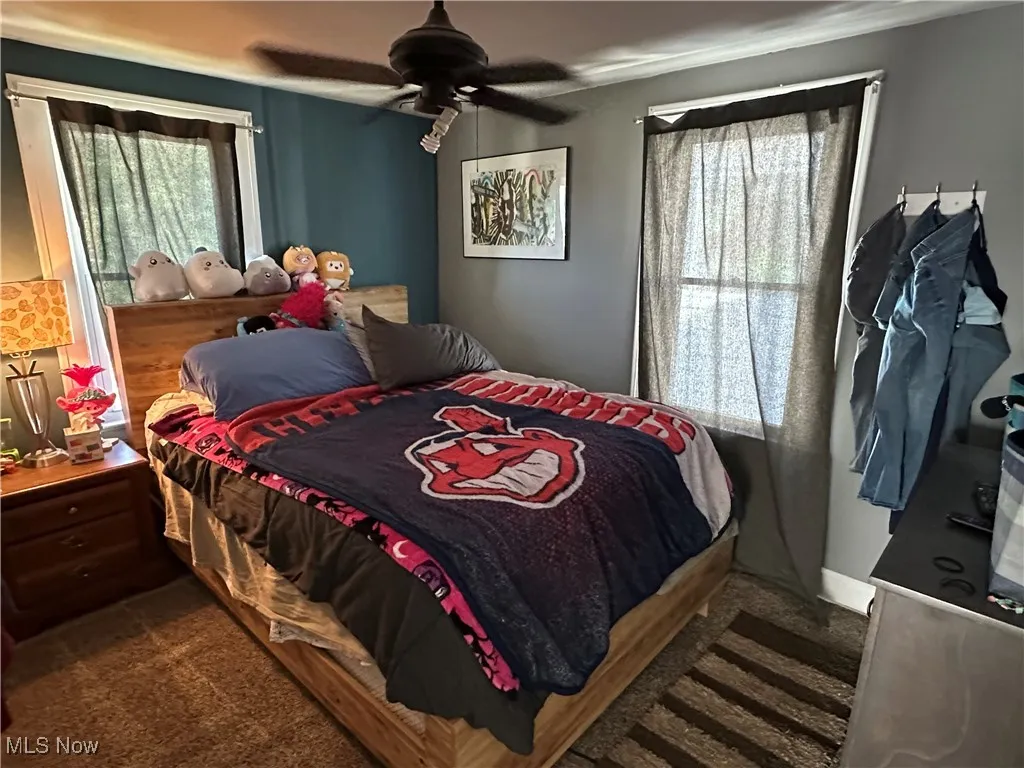 Bedroom featuring dark carpet and a ceiling fan