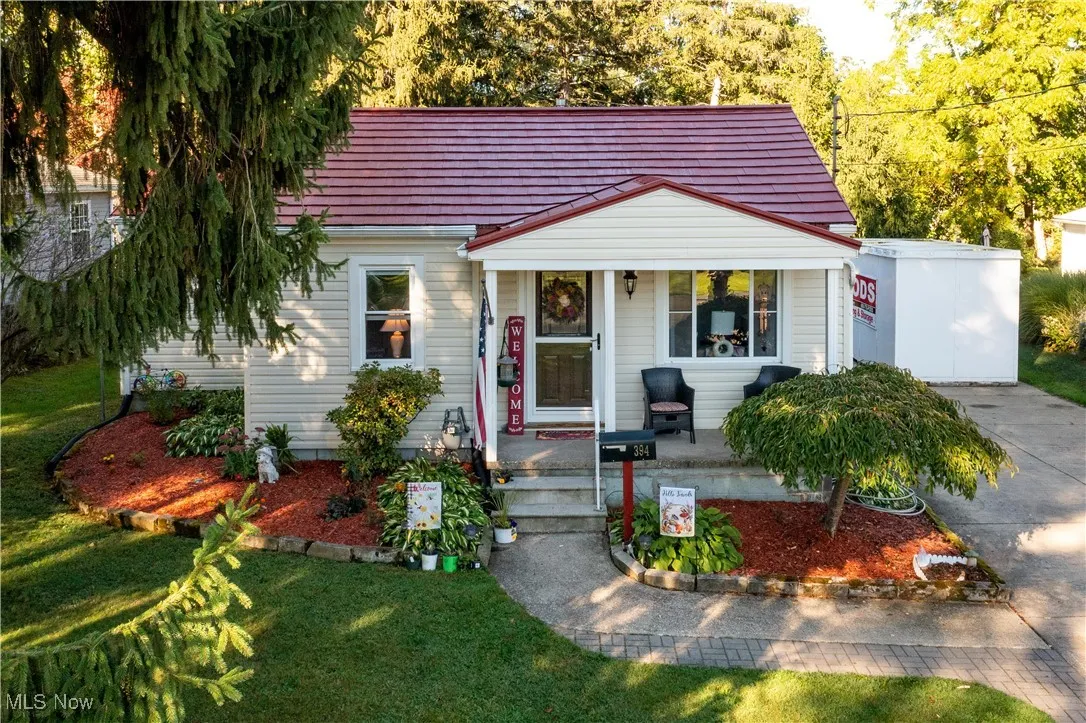 View of front facade featuring covered porch and a front yard