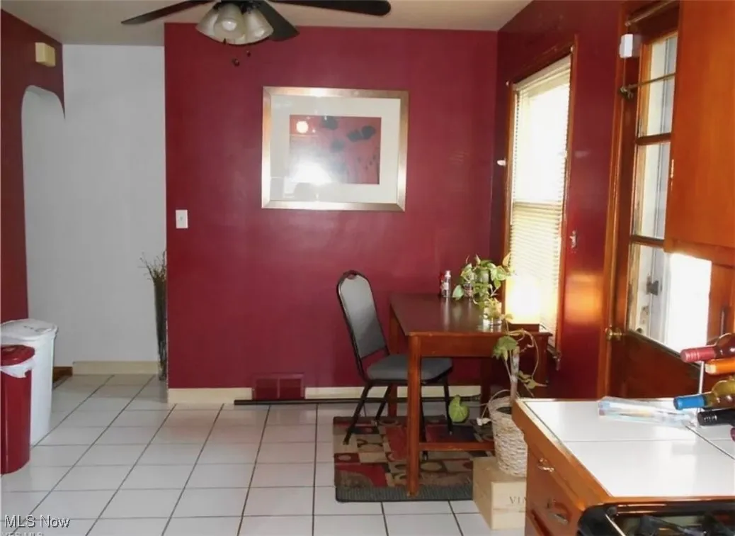 Dining room with a ceiling fan and light tile patterned flooring