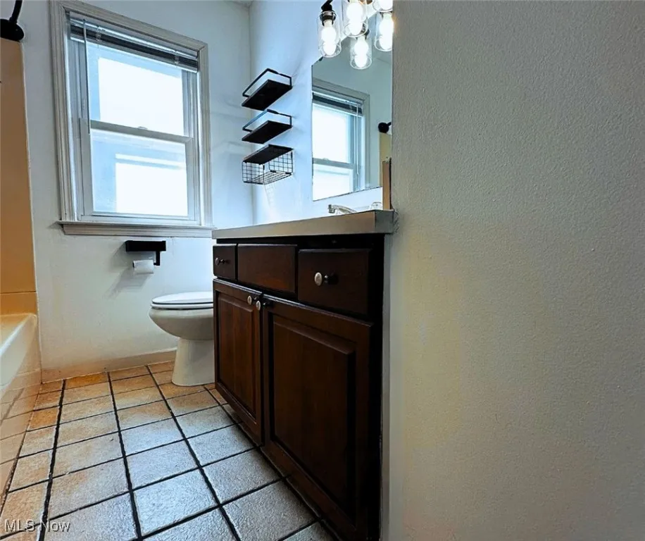 Bathroom with vanity, light tile patterned flooring, a chandelier, and shower / washtub combination