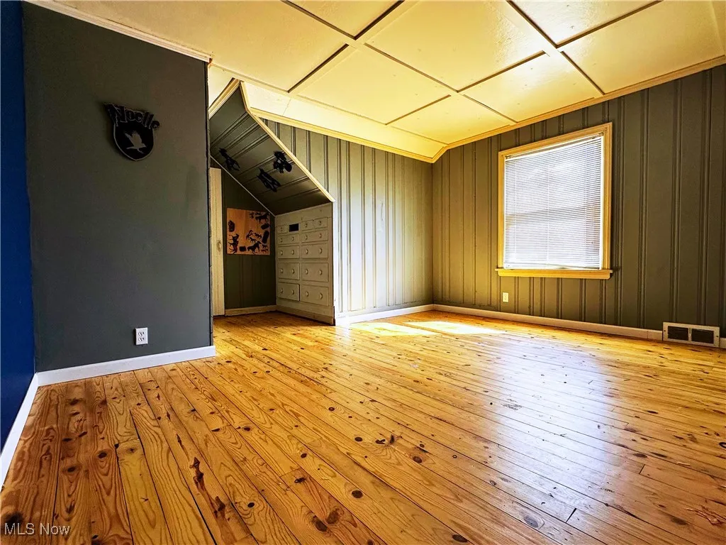 Bonus room with light wood-style flooring and baseboards