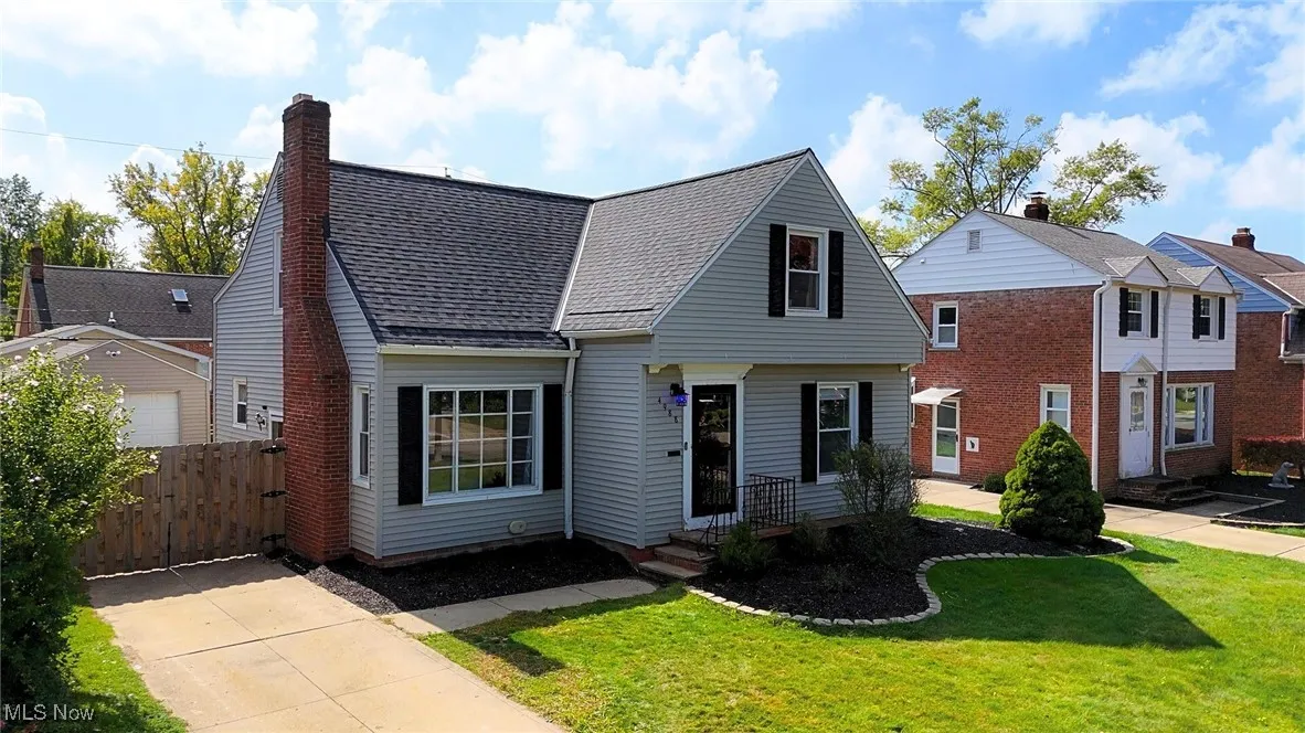 View of front facade with a shingled roof and a chimney