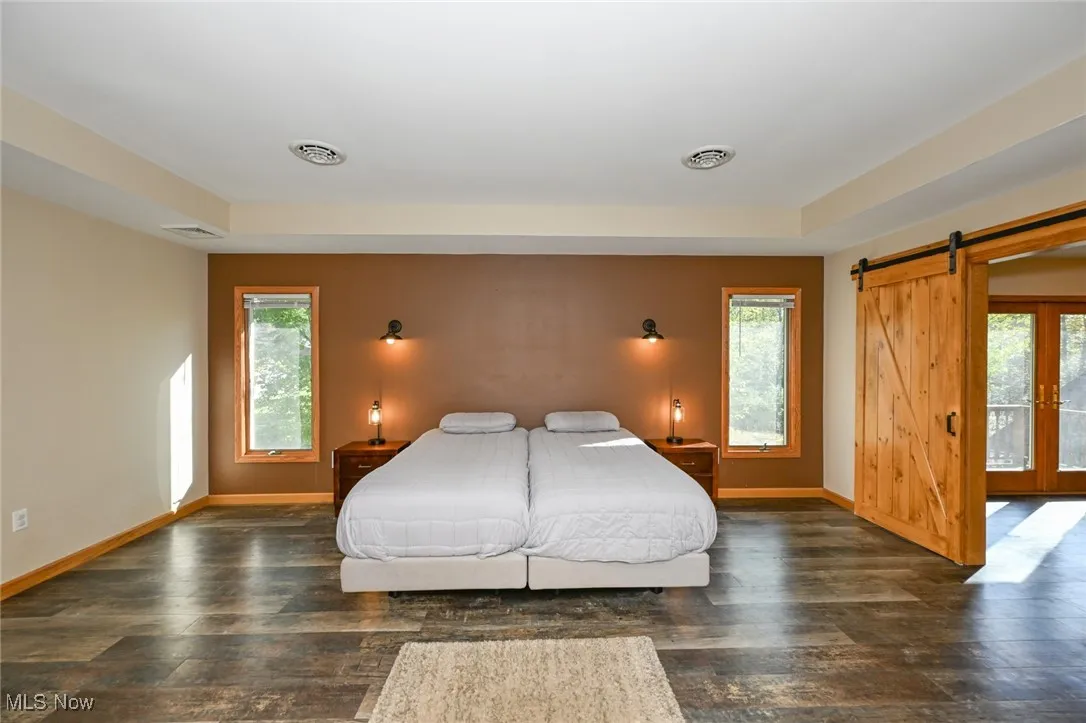 Master bedroom with plenty of natural light and a tray ceiling