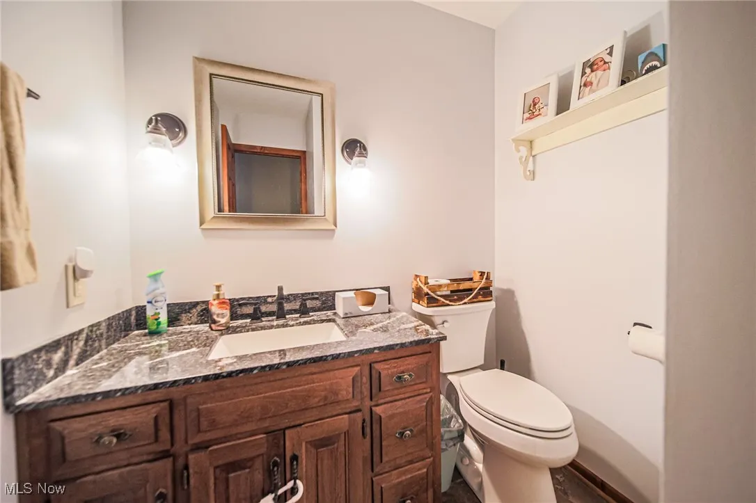 Half bathroom with vanity and toilet