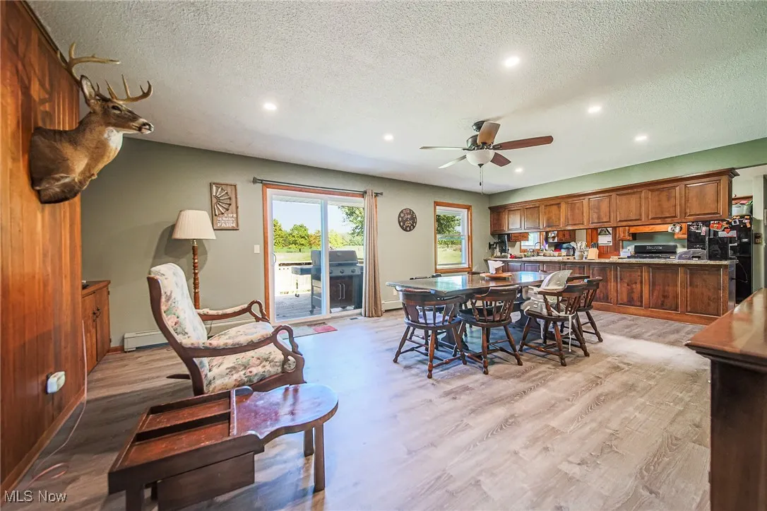 Dining room with a textured ceiling, recessed lighting, light wood-style floors, ceiling fan, and a baseboard heating unit