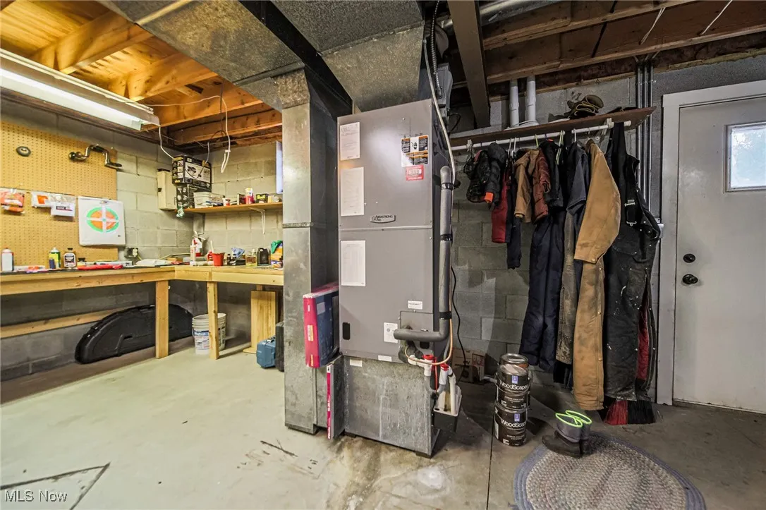 Unfinished basement featuring a workshop area and heating unit