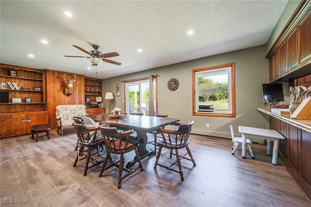 Dining area with a textured ceiling, recessed lighting, light wood-style flooring, a ceiling fan, and built in features