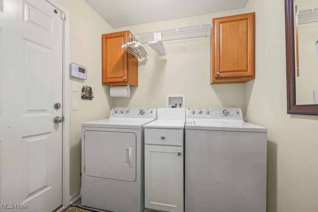Laundry room with cabinet space and washer and clothes dryer