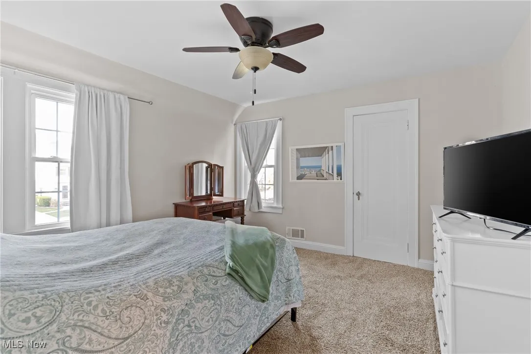 Bedroom featuring light colored carpet and ceiling fan