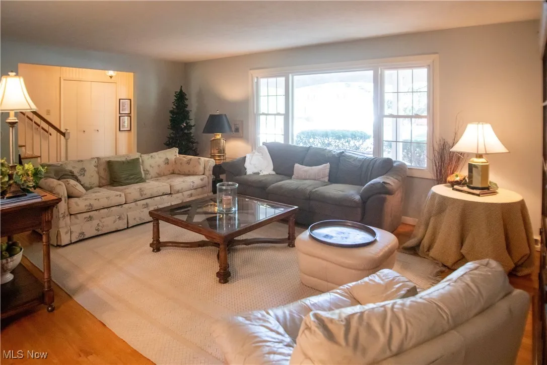 Living room area with wood finished floors and stairway