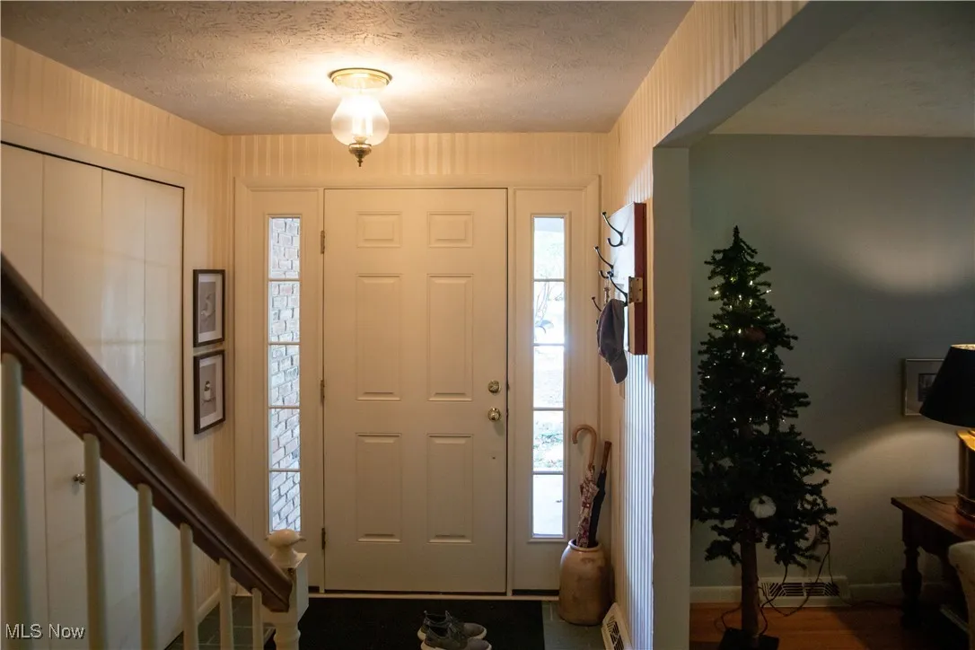 Entrance foyer featuring a textured ceiling and wood finished floors