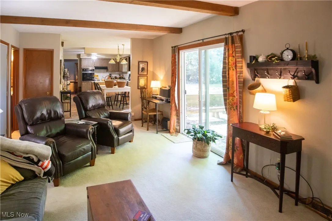 Family room with beamed ceiling and carpet flooring