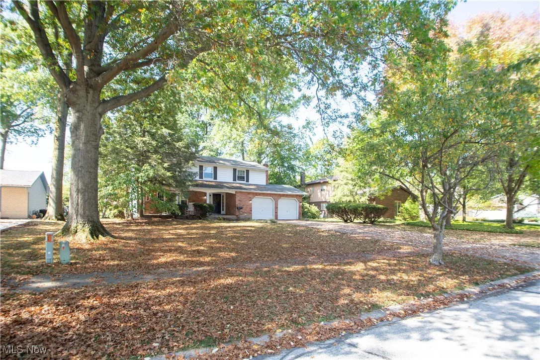 Traditional-style house with a garage, driveway, and brick siding
