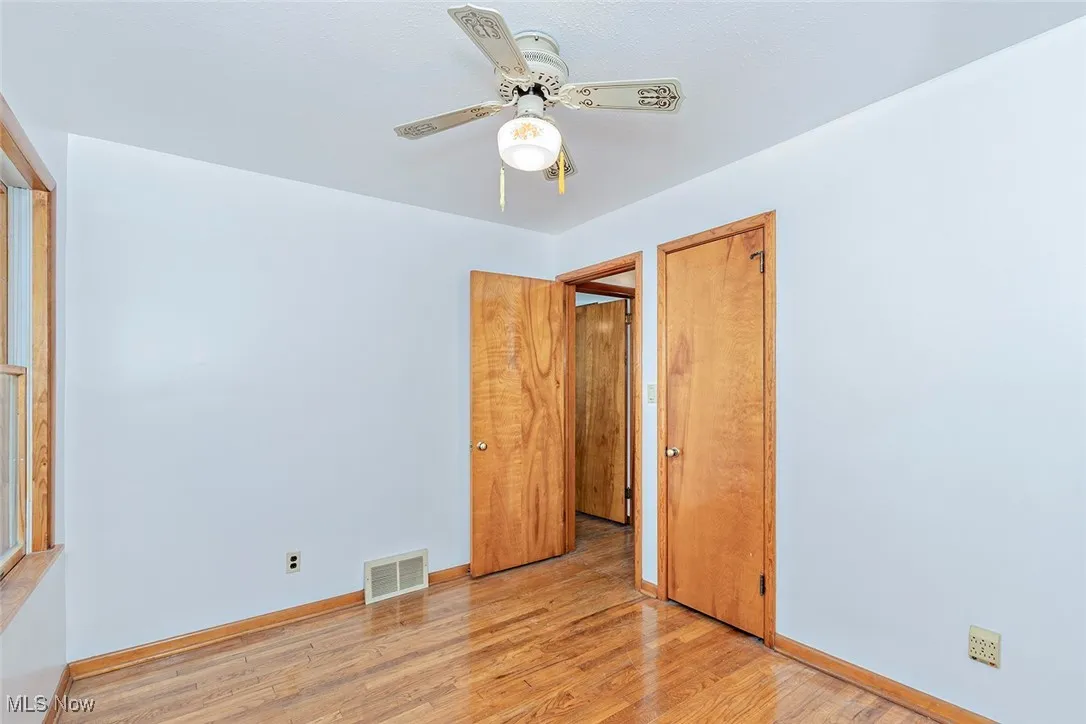 Unfurnished bedroom with light wood-style floors and ceiling fan