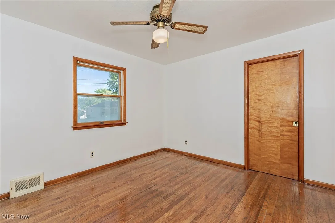 Unfurnished room with wood-type flooring and ceiling fan