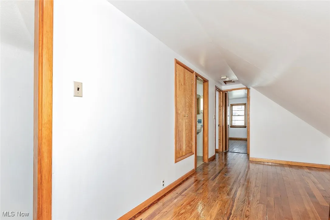 Additional living space featuring hardwood / wood-style flooring and vaulted ceiling