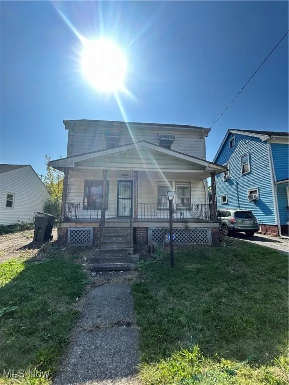 View of front of house featuring covered porch and a front lawn