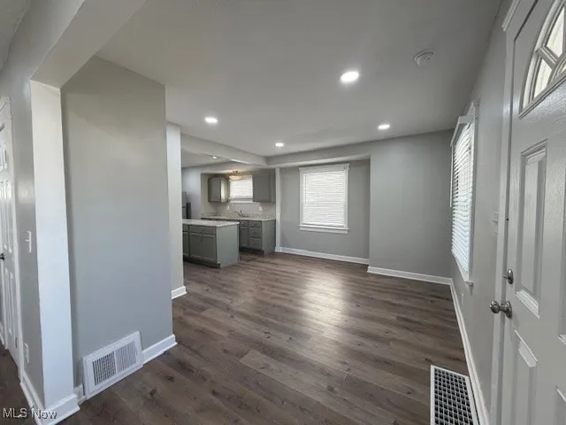 Unfurnished living room featuring dark wood finished floors and recessed lighting