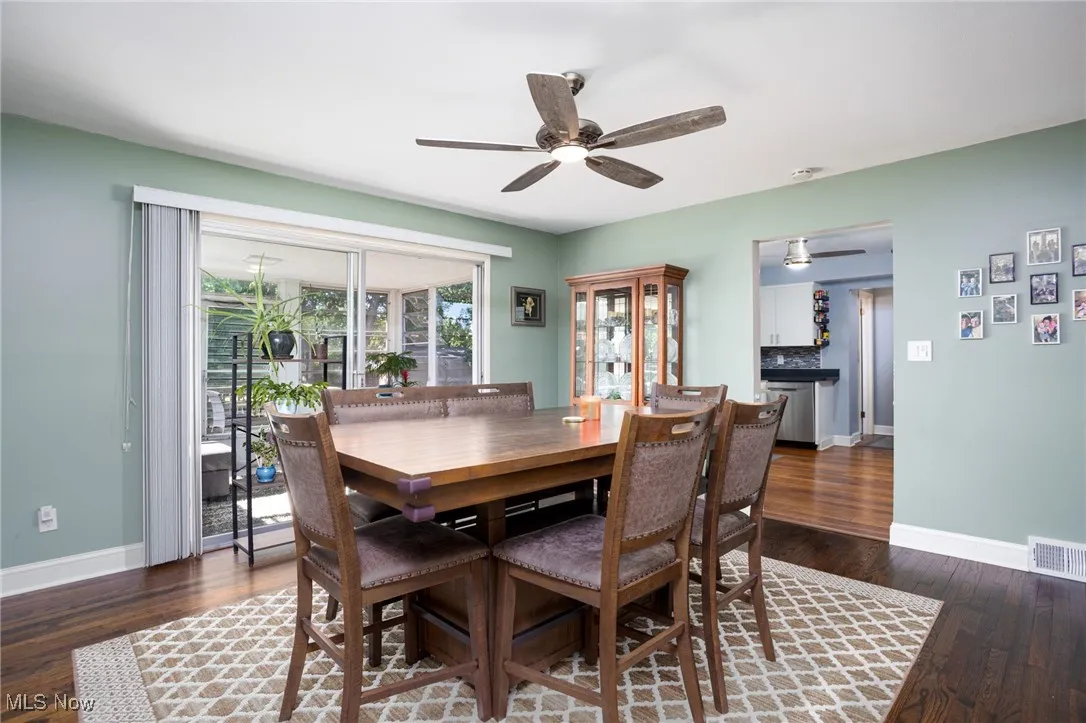 Dining room with dark wood-type flooring and ceiling fan