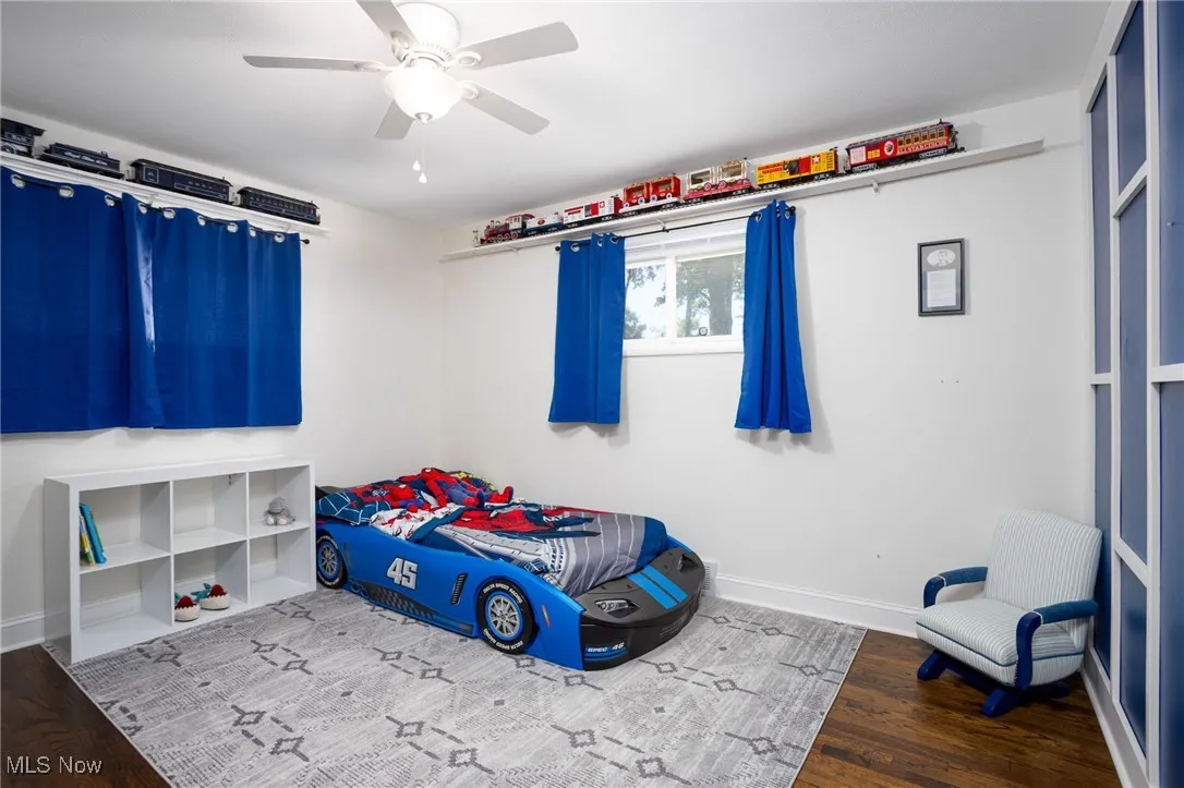 Unfurnished bedroom with dark wood-style floors and ceiling fan