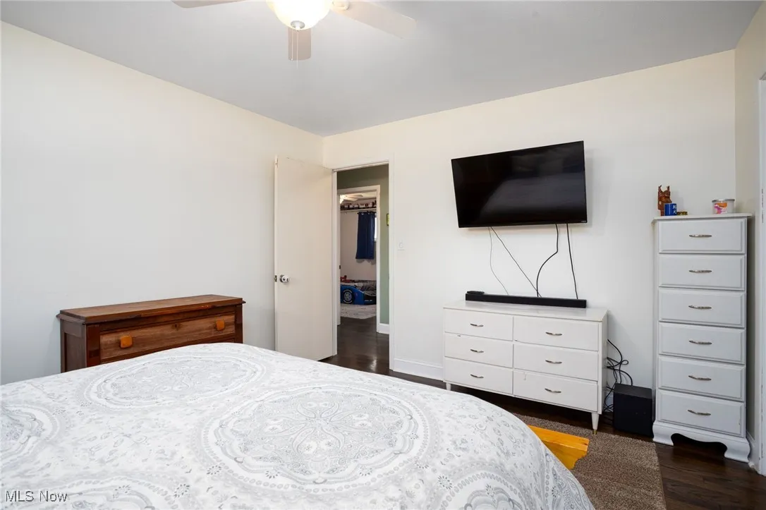 Bedroom with dark wood-type flooring and a ceiling fan