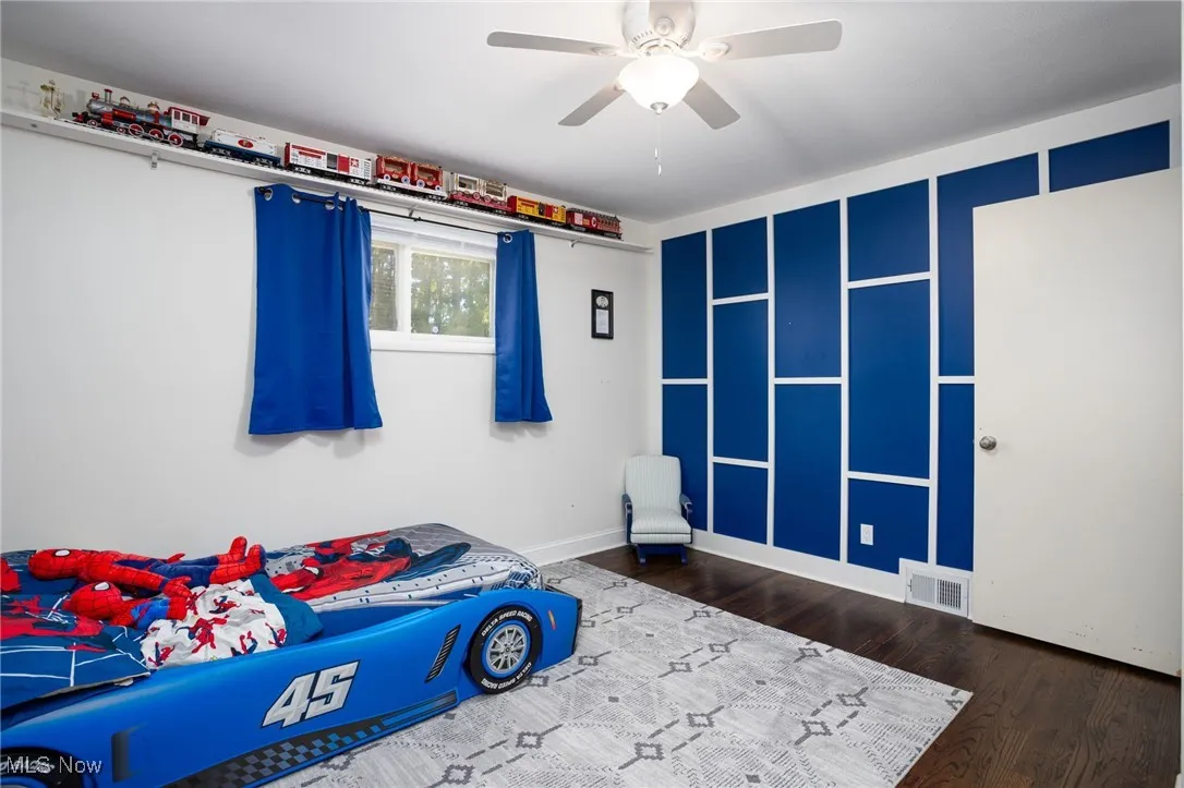 Bedroom with dark wood-style floors and ceiling fan
