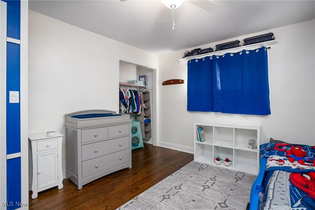 Bedroom featuring dark wood-style flooring, a closet, and ceiling fan
