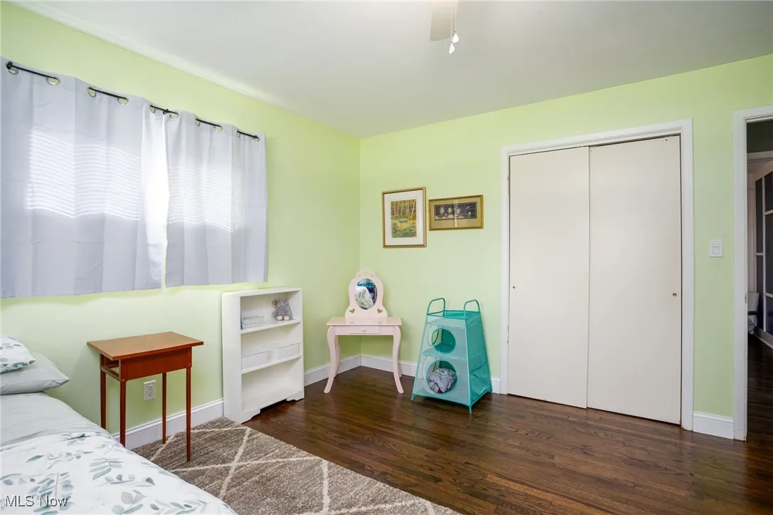 Bedroom featuring a closet, dark wood-type flooring, and ceiling fan