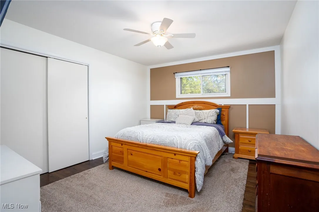 Bedroom with a closet, wood finished floors, and a ceiling fan