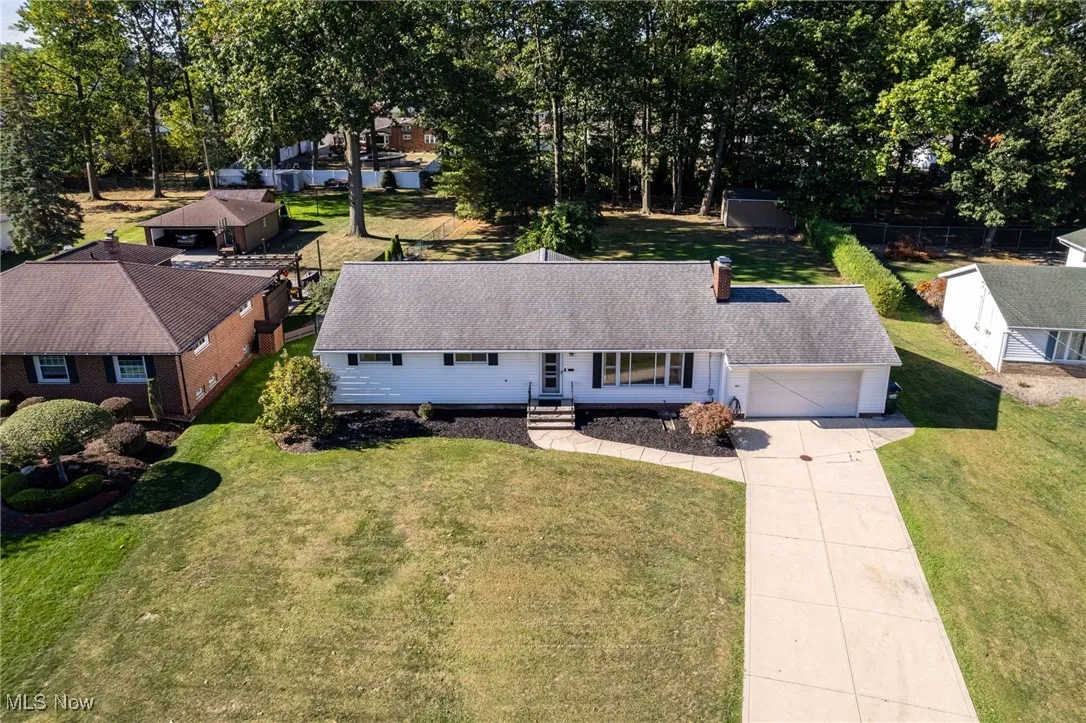 View of front facade with driveway, a front yard, and an attached garage