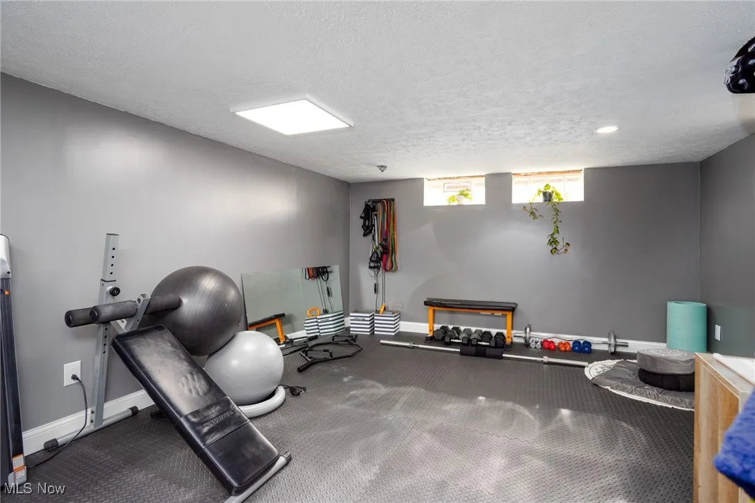 Exercise area with a textured ceiling and carpet