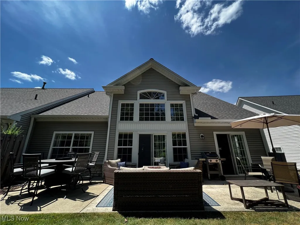 Back of house featuring a shingled roof, a patio, outdoor lounge area, and outdoor dining space