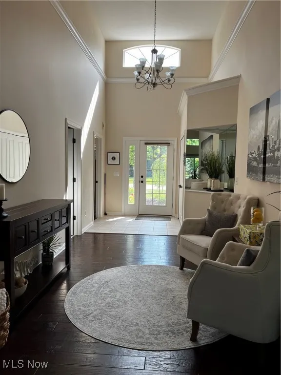 Foyer featuring a high ceiling, hardwood / wood-style flooring, and a chandelier