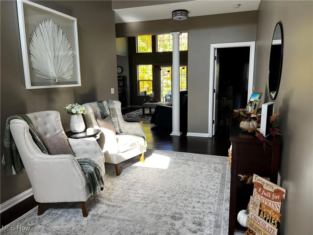 Living area featuring dark wood-style floors and decorative columns