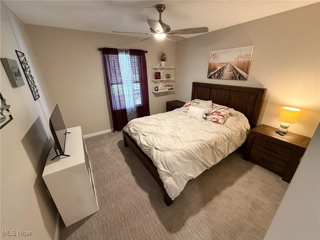 Bedroom featuring light colored carpet and ceiling fan