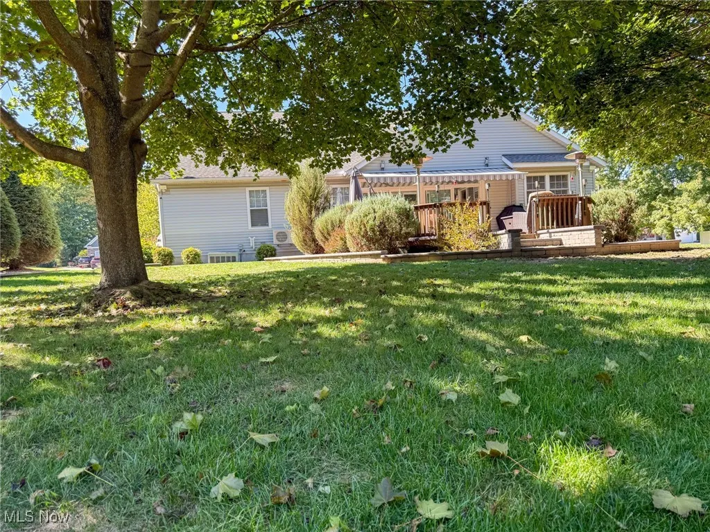 Rear view of house with a yard and a deck
