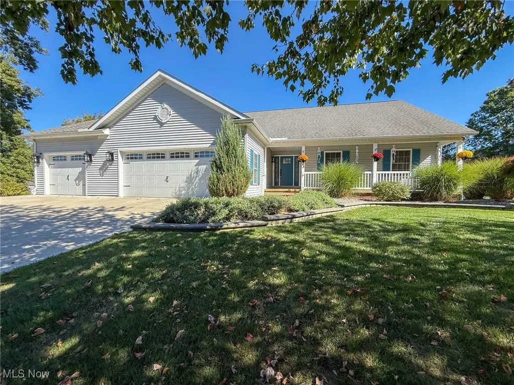 Single story home featuring concrete driveway, a porch, an attached garage, a front yard, and roof with shingles