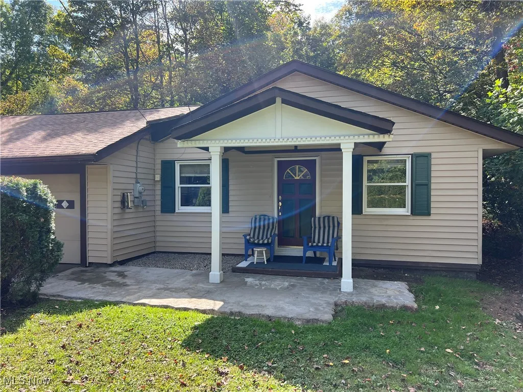 Bungalow-style home with a porch, a front lawn, and a garage