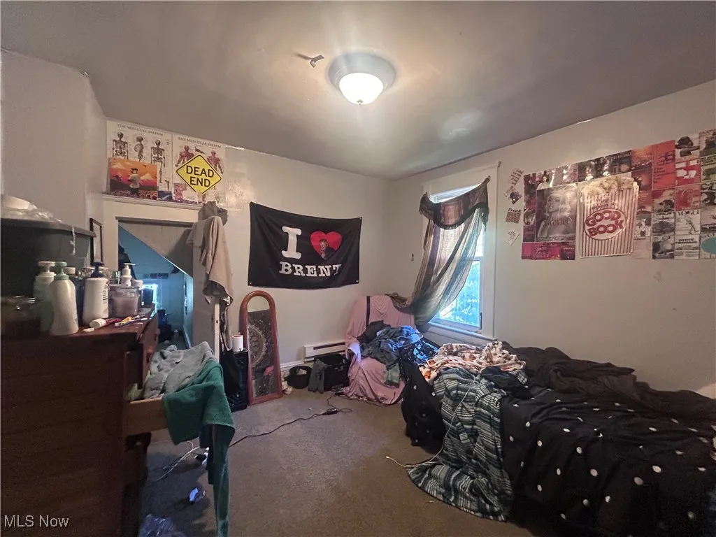 Carpeted bedroom with baseboard heating