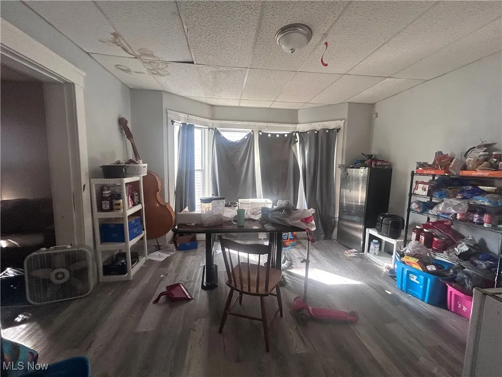 Recreation room with a drop ceiling and wood finished floors