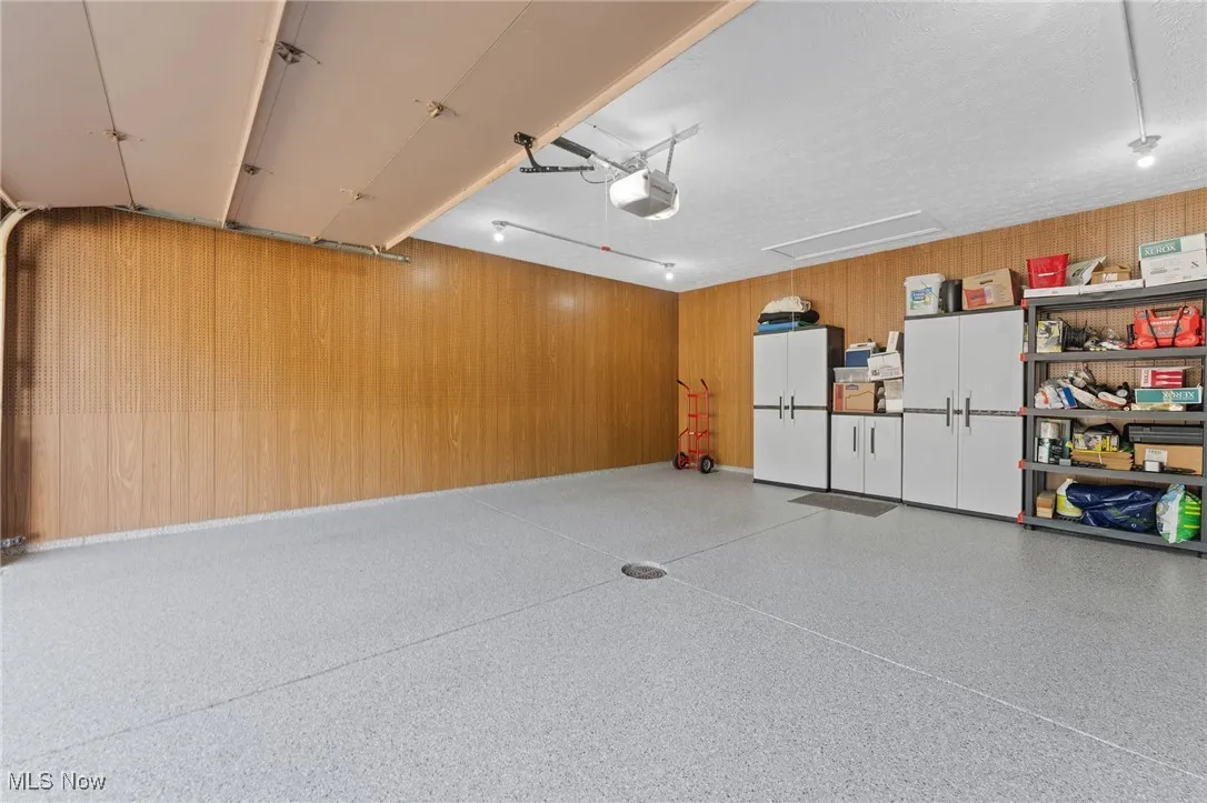 Garage with wood walls and a garage door opener