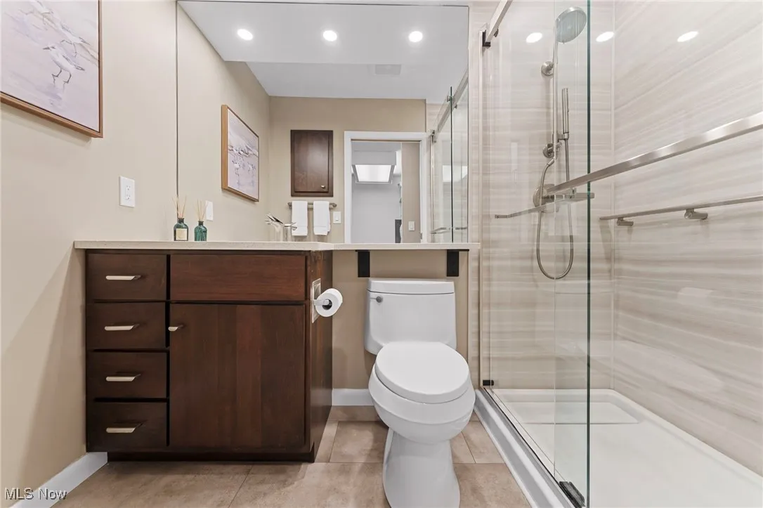 Full bathroom featuring vanity, a shower stall, light tile patterned floors, and recessed lighting
