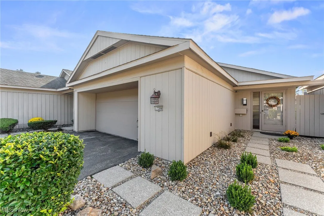 View of front of house with asphalt driveway and an attached garage