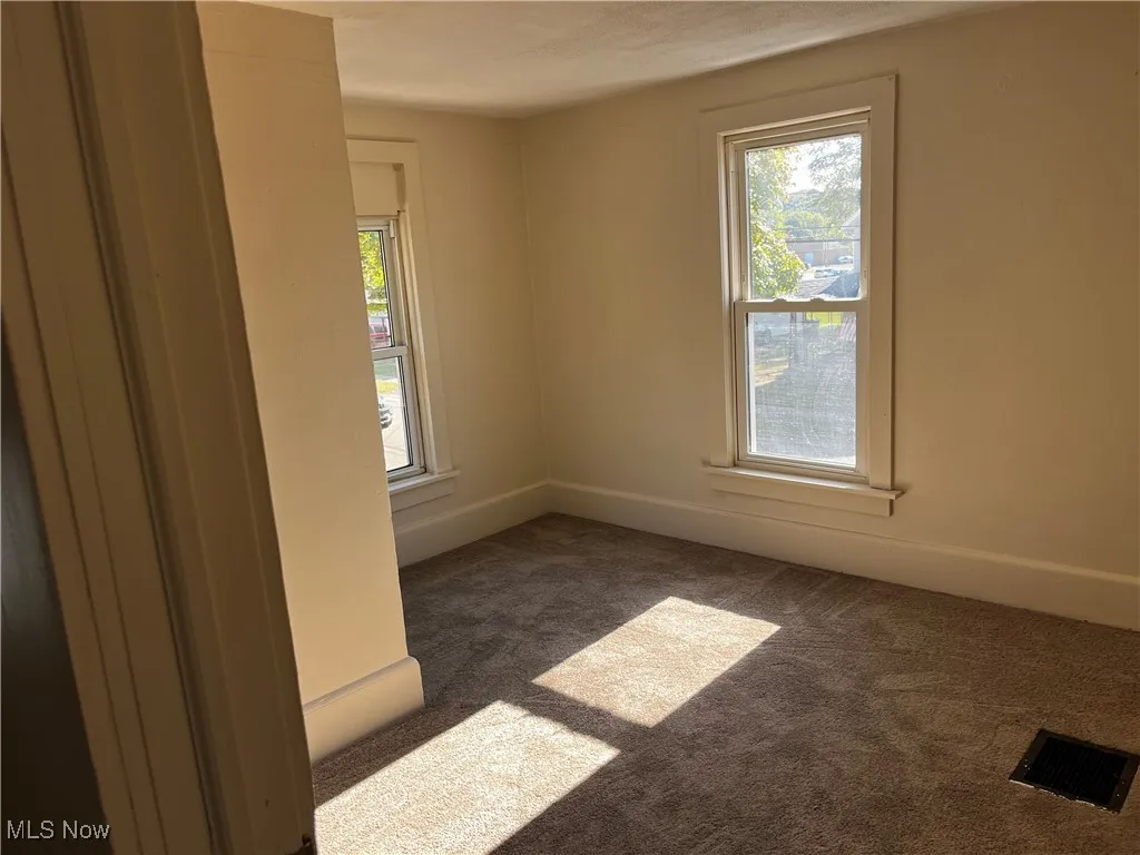 Empty room featuring healthy amount of natural light and carpet floors