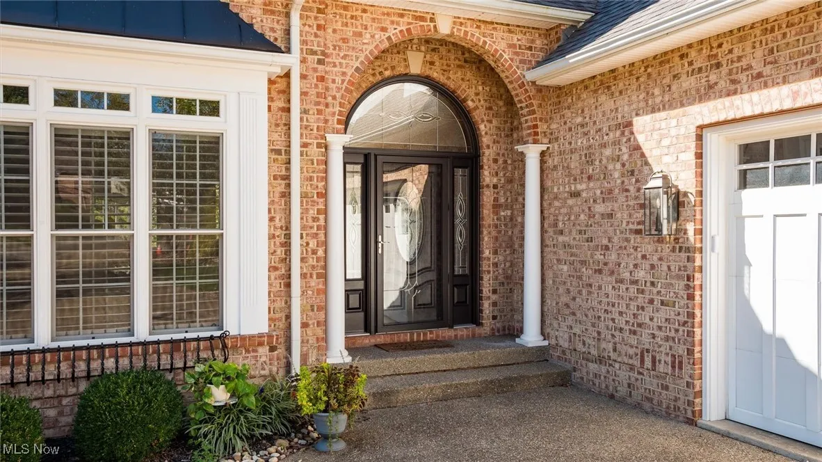 Doorway to property featuring brick siding